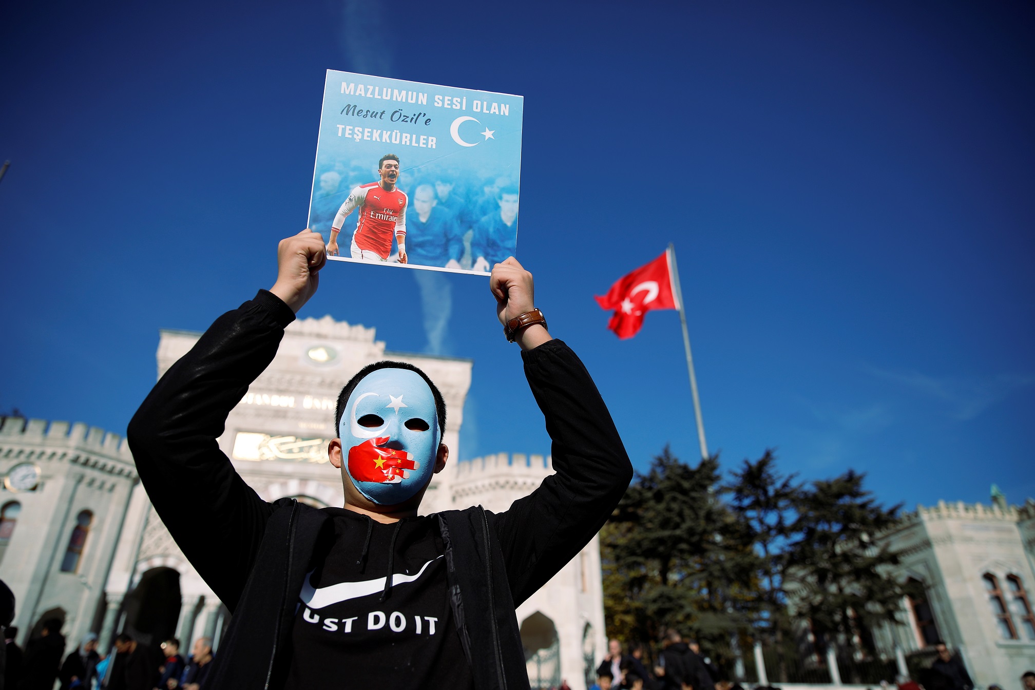 Një demonstrues i komunitetit ujgur mban në duar një poster me një fotografi të Ozilit gjatë një proteste kundër Kinës në Stamboll, Turqi, më 14 dhjetor, 2019. Foto: Reuters