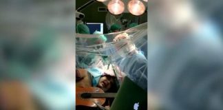 Muzikanti në Torino luan në kitarë gjatë një operacioni në tru