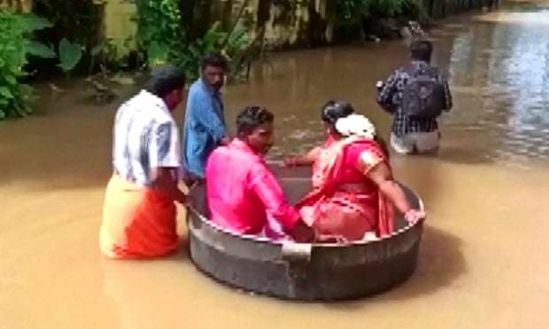 Pas përmbytjeve, çifti indian lundron në një tenxhere të madhe për të shkuar në dasmën e tyre