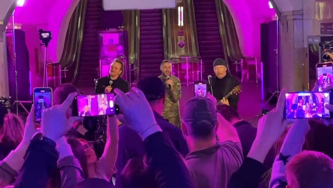 U2 performon brenda një stacioni treni në Ukrainë