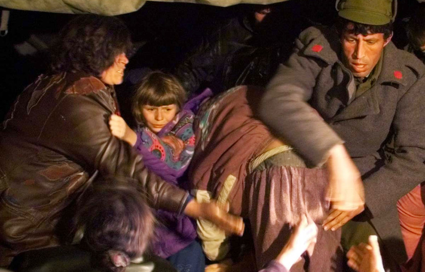 Refugjatët shqiptarë nga rajoni i Skenderajt nxitojnë drejt kamionit të tejmbushur