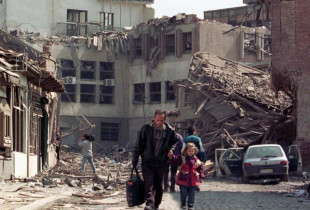 Babai me të bijën nëpër gërmadha pas bombardimeve. Prishtinë, 7 prill 1999 (Foto: Reuters)
