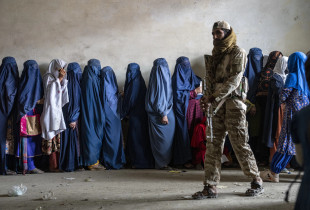 Një luftëtar taleban qëndron roje teksa gratë presin të marrin racione ushqimore Foto: AP