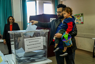 Zgjedhjet lokale ne Turqi, nje burre duke mbajtur femijen ne dore voton ne Ankara