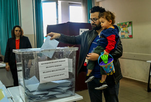 Zgjedhjet lokale ne Turqi, nje burre duke mbajtur femijen ne dore voton ne Ankara