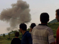 Qytetarët shqiptarë shikojnë një re të madhe tymi pasi një aeroplan luftarak i NATO-s thuhet se goditi caqet serbe pranë kufirit midis Shqipërinë e Kosovës në Morinë, në Shqipërinë veriore, të hënën, 31 maj 1999 (Foto: Associated Press / Luca Bruno)