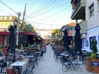 ...ajo nuk ishte vetëm vend, por ishte gjendje reale. Një vend që nuk fle, një kohë që ikën, një miqësi që nuk kërkon më shumë sesa të jesh aty. Në heshtje, me një gotë verë, një qofte, një puro