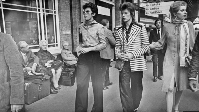 Antony Price me David Bowien dhe gruan e tij Angie Bowie, në stacionin King's Cros në Londër, viti 1973