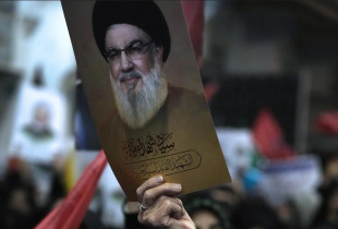 Nje protestuese duke mbajtur foton e Hassan Nasrallah