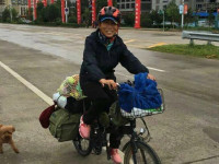 Li Dongju e shoqëruar nga qeni i saj gjatë udhëtimit me biçikletë nëpër Kinë në vitin 2015.